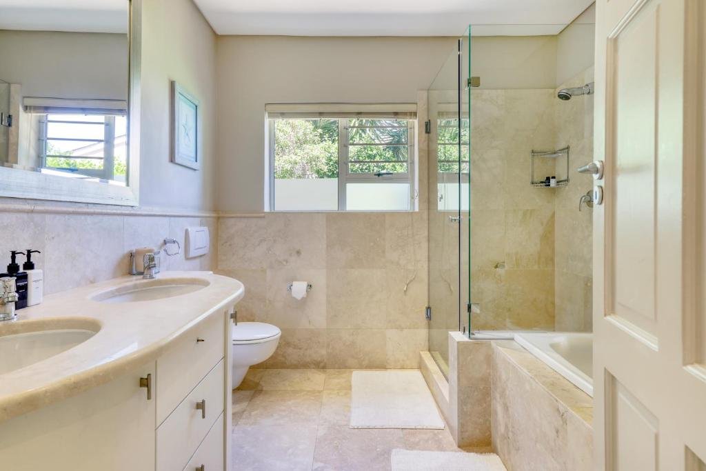 Marble bathroom with glass shower and dual vanity