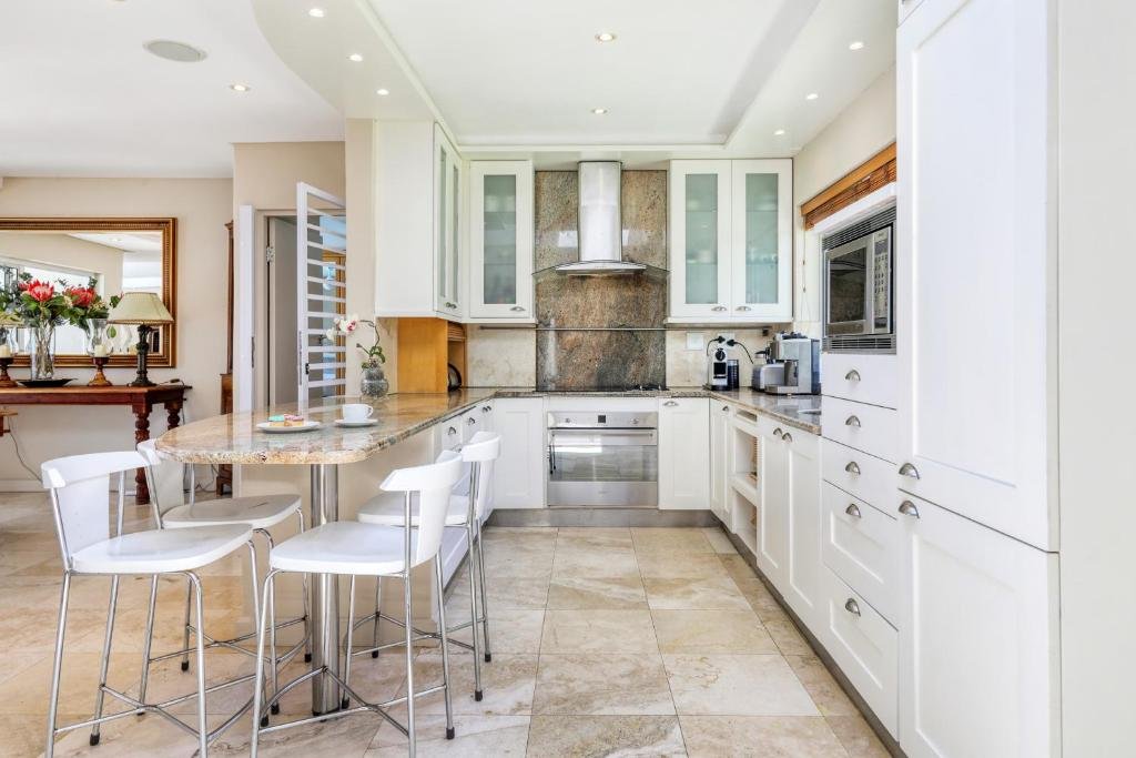 Modern white kitchen with granite counters and breakfast bar