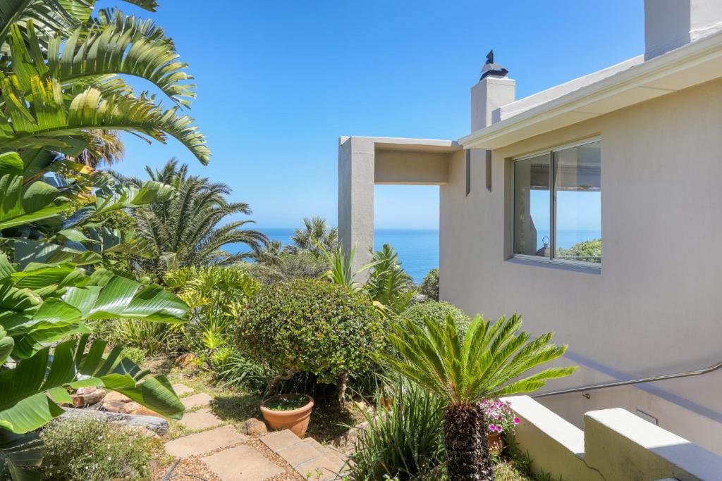 Villa exterior with tropical garden and ocean glimpse