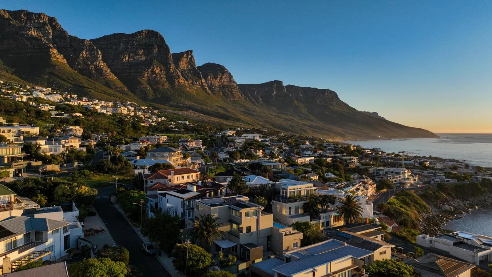 Camps Bay spread out beneath the Twelve Apostles at sunset
