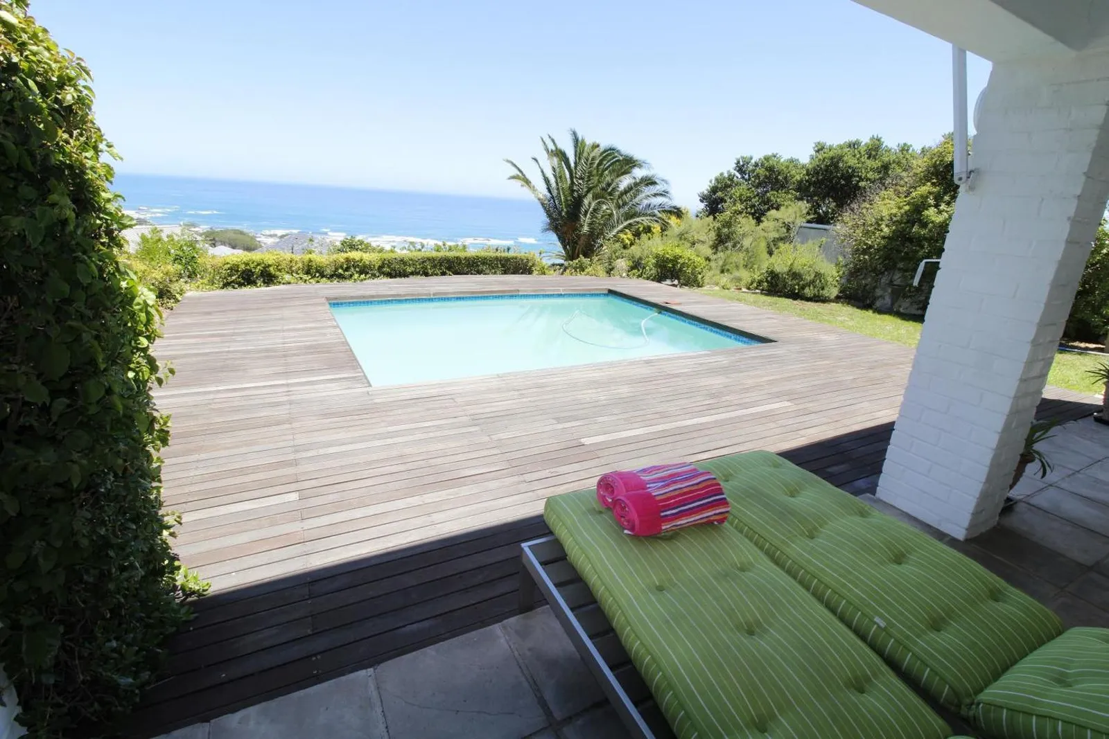 Pool and timber deck with the sea beyond the garden