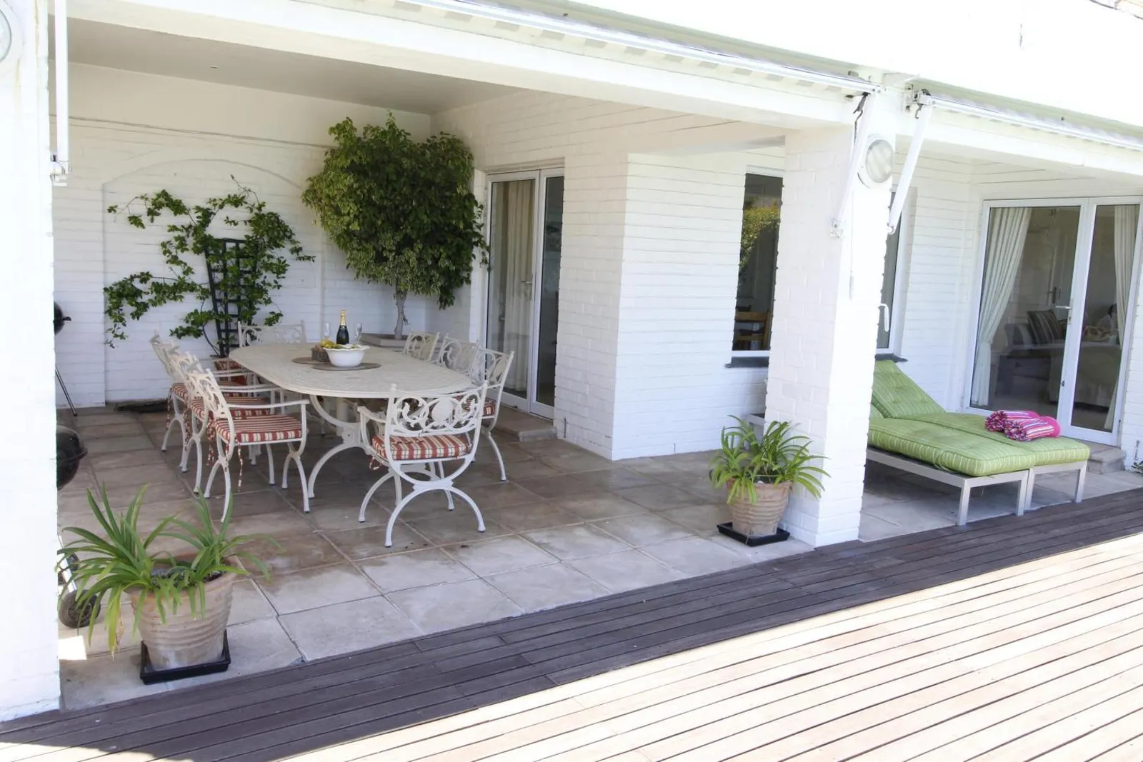 Covered veranda with a dining table and climbing greenery