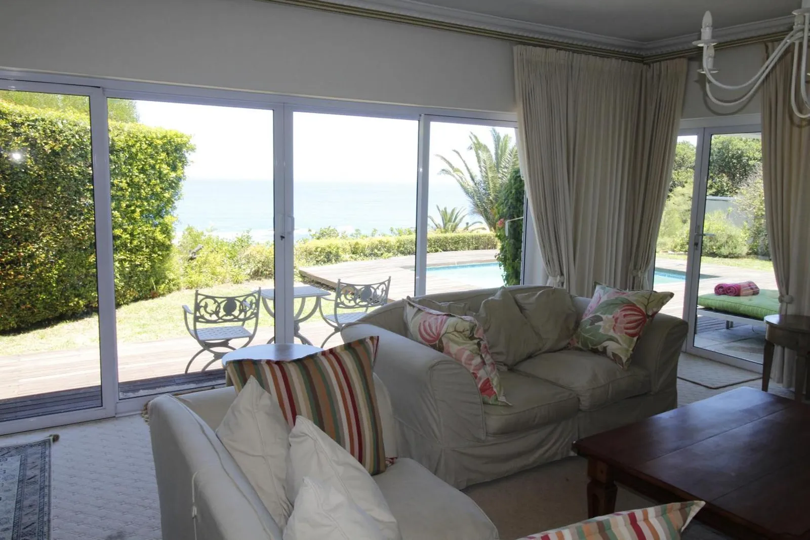 Living room opening onto the pool terrace and lawn