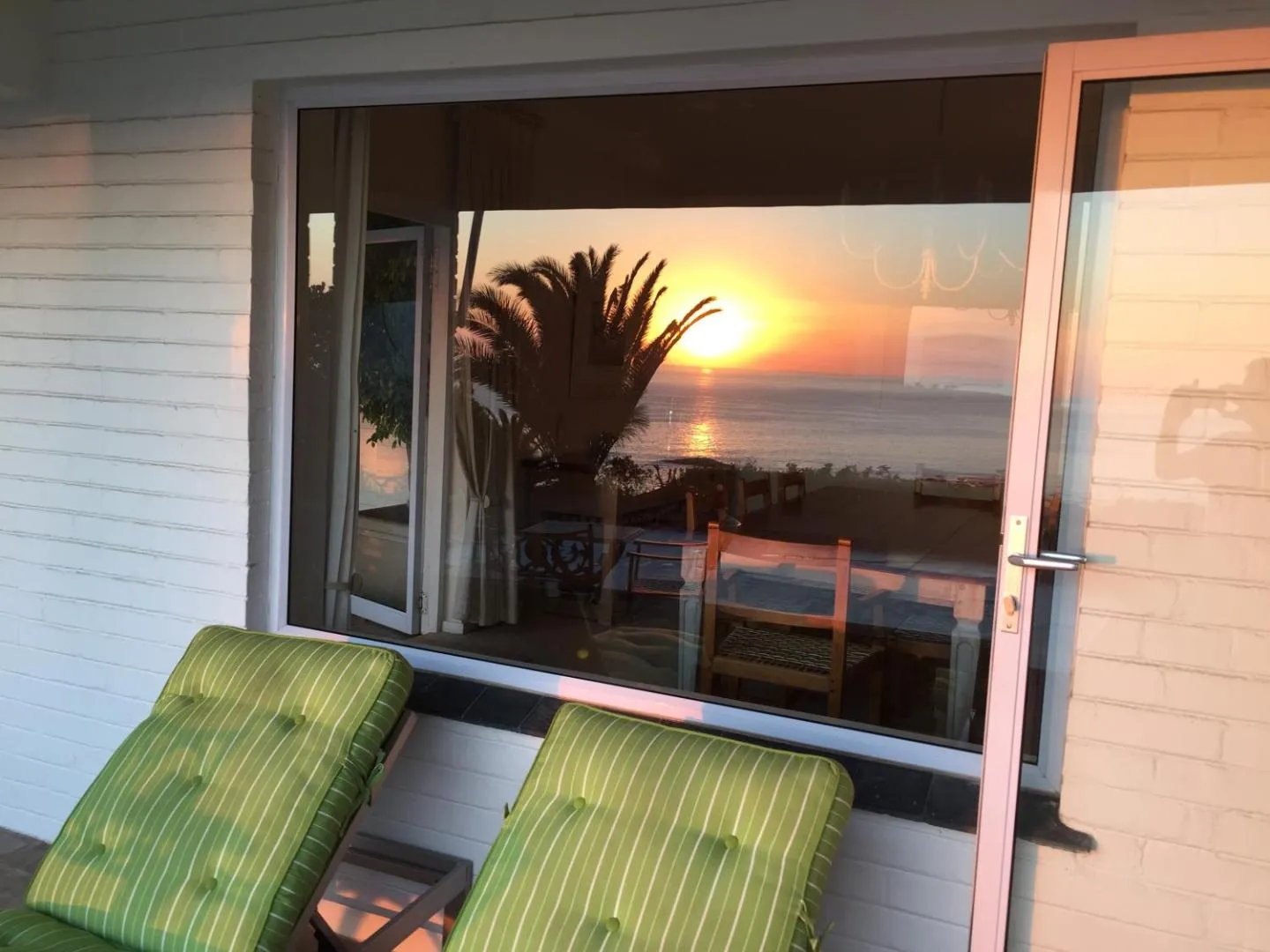 Sunset over the sea seen through the villa's open doors