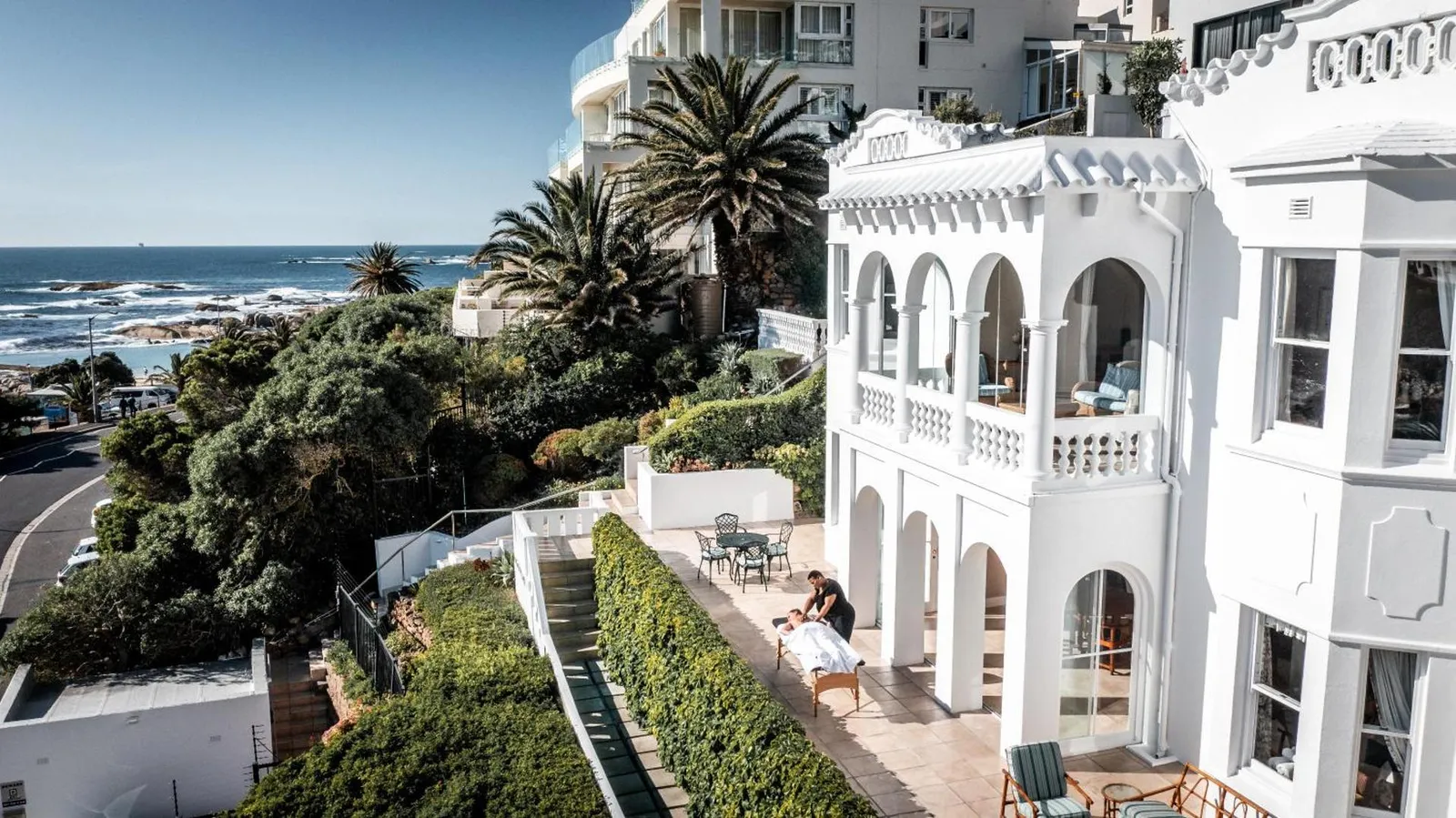 White colonial-style villa above a terraced garden