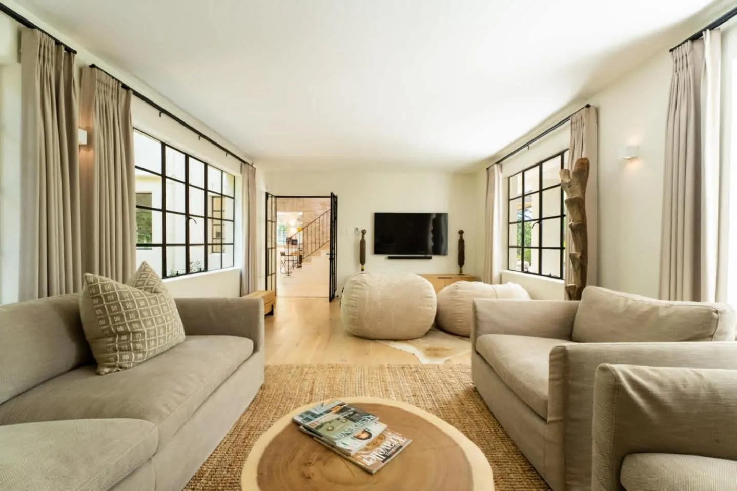 Living room with black steel windows and linen sofas