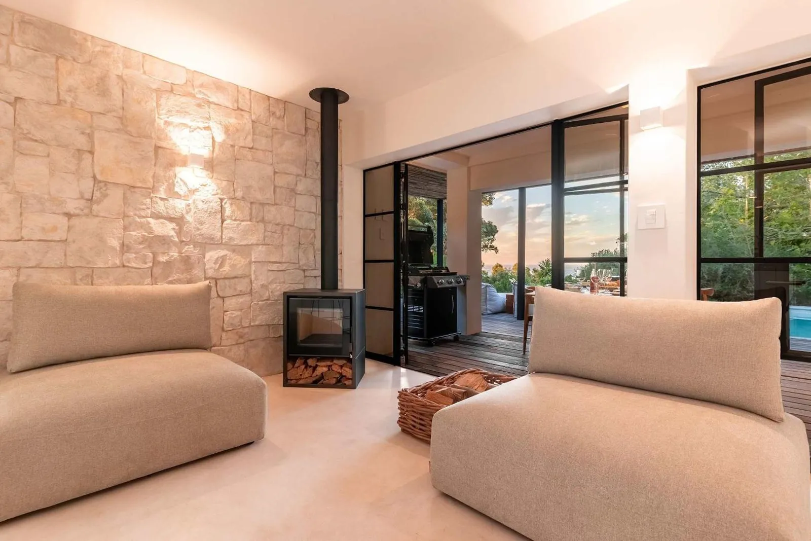 Lounge with a wood burner against the stone wall