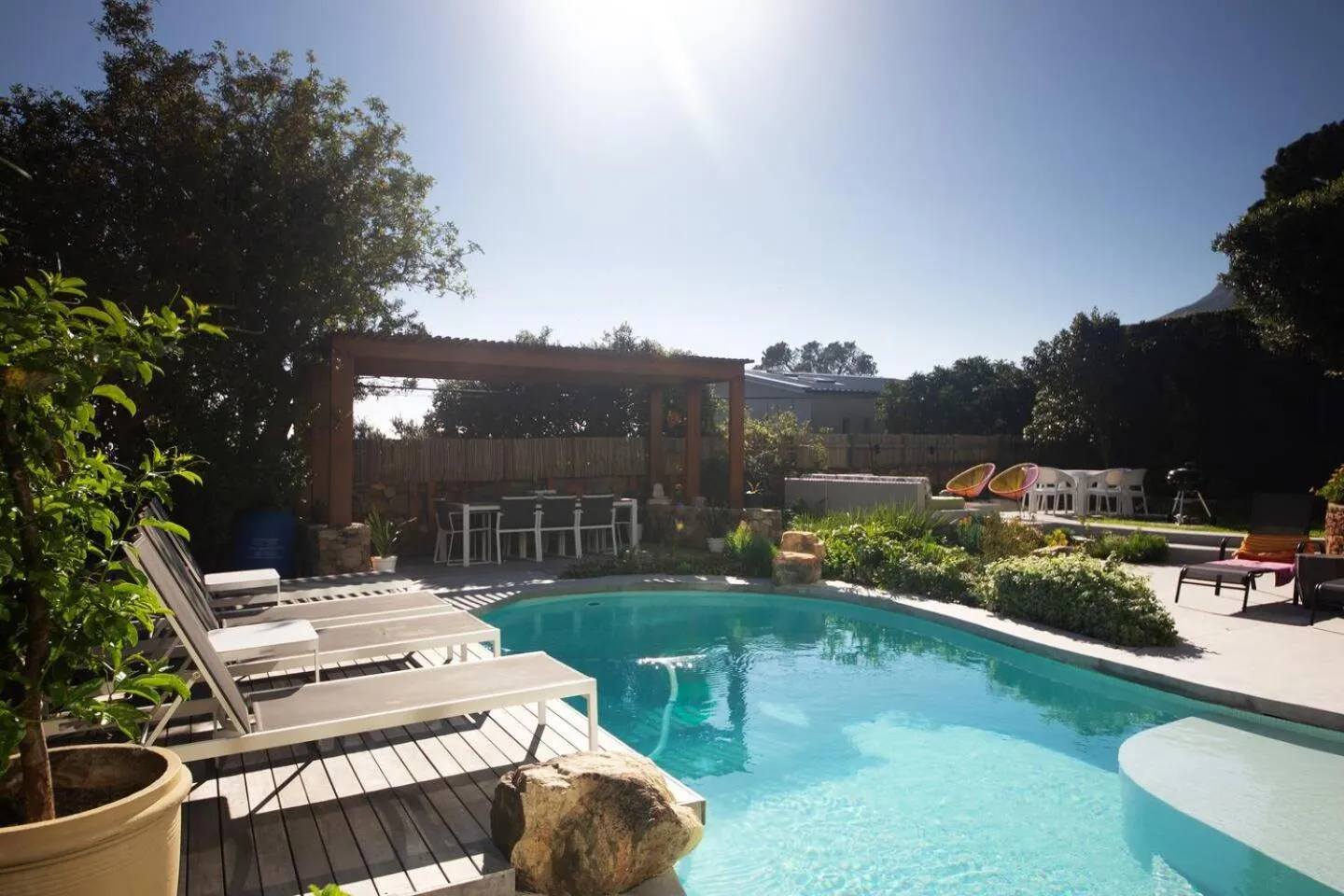 Pool with sun loungers and a timber pergola