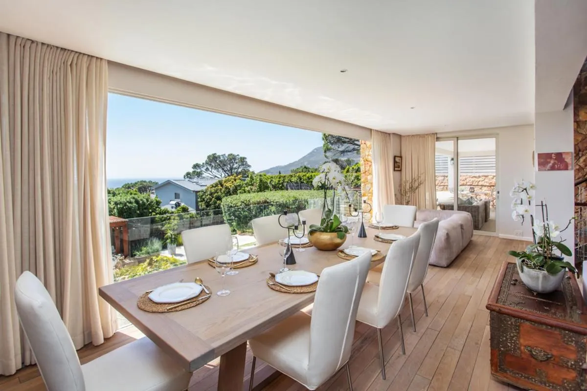 Dining table set below a full-width sea-facing window