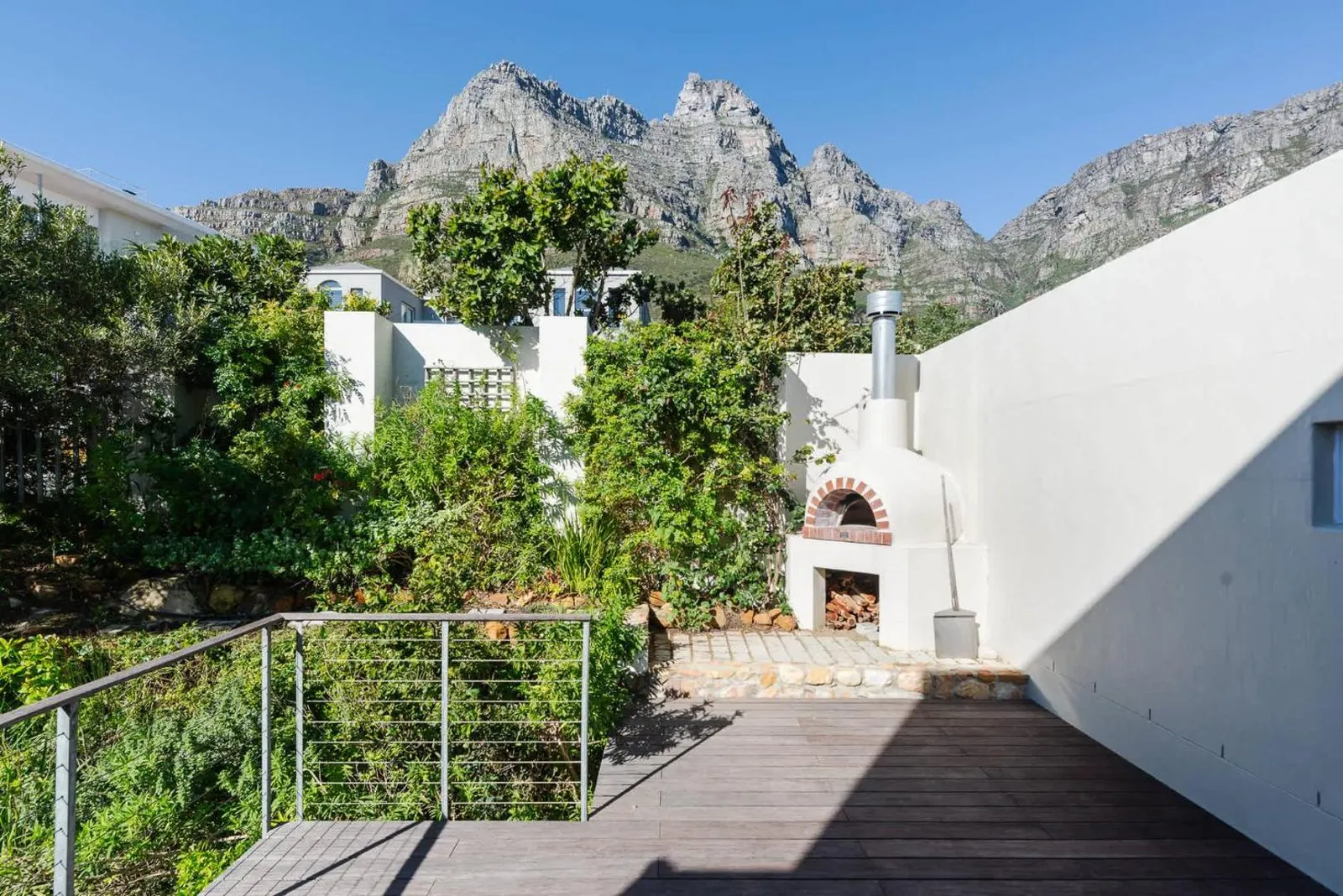 Deck with a wood-fired pizza oven under the mountains