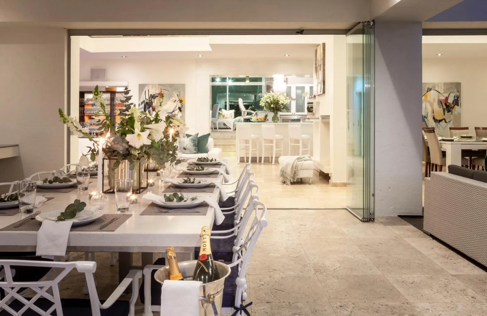 Dining table laid for a meal with the kitchen beyond