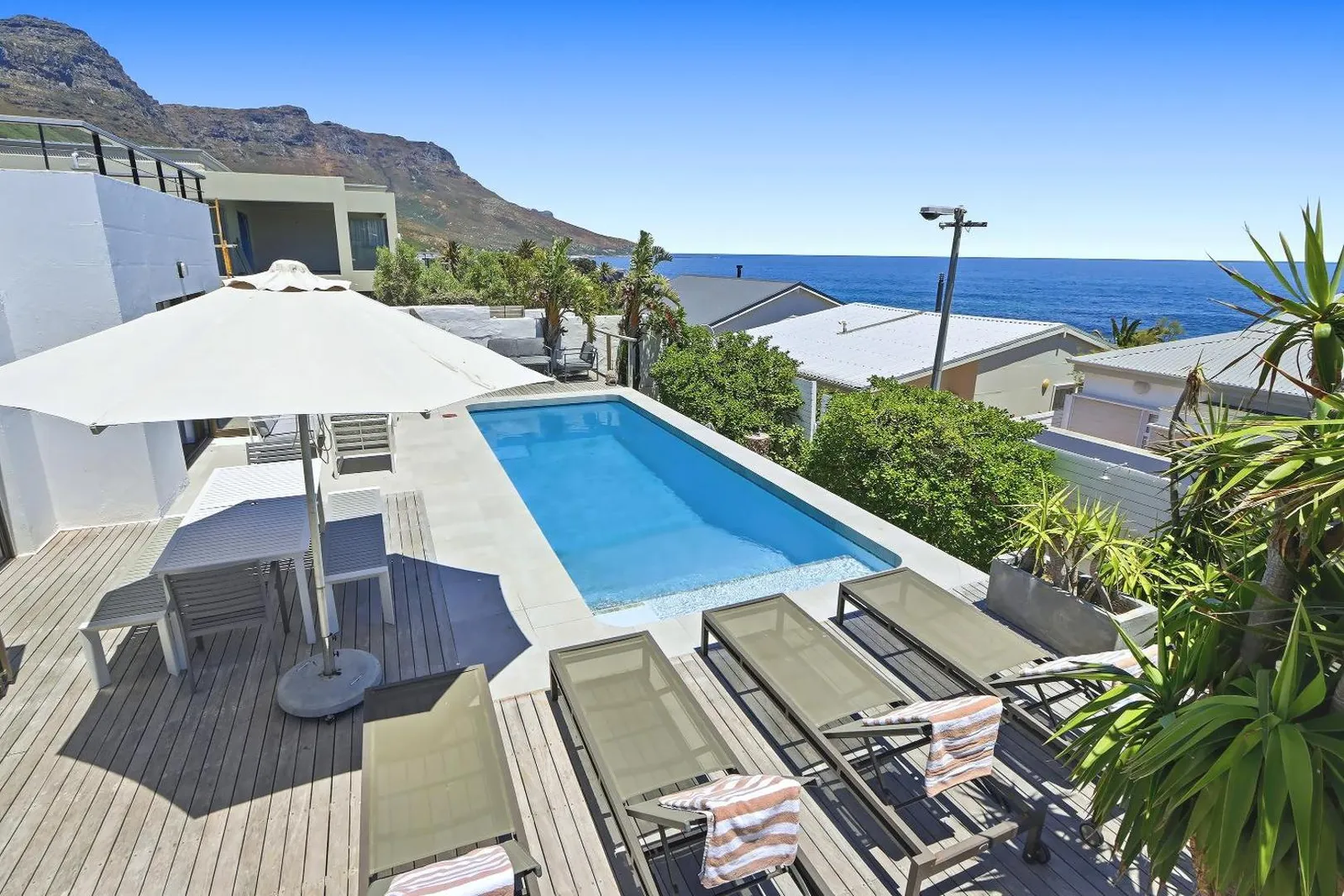 Pool with sun loungers and the ocean on the horizon