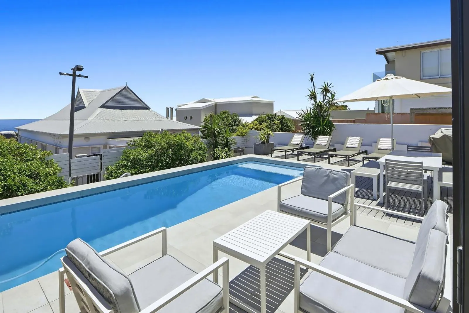 Pool and sun deck with parasols and seating