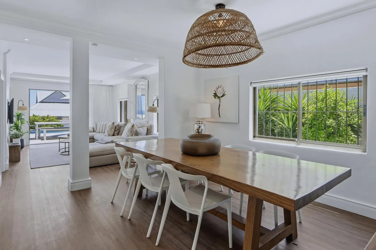 Dining table below a woven pendant light