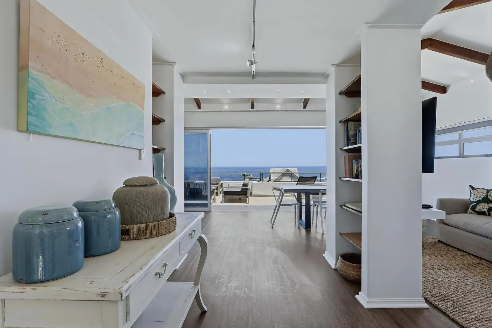 Living area with sea-view doors and coastal artwork