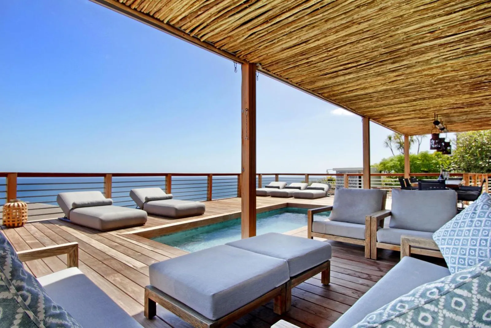 Covered deck with daybeds beside the pool