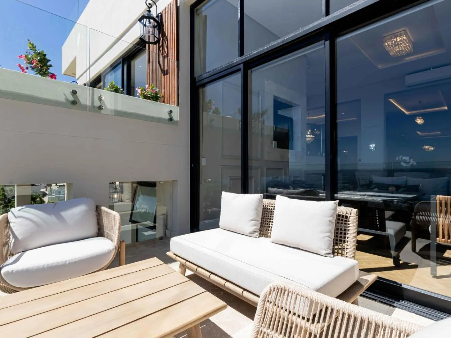 Terrace sofas with the ocean through full-height glass