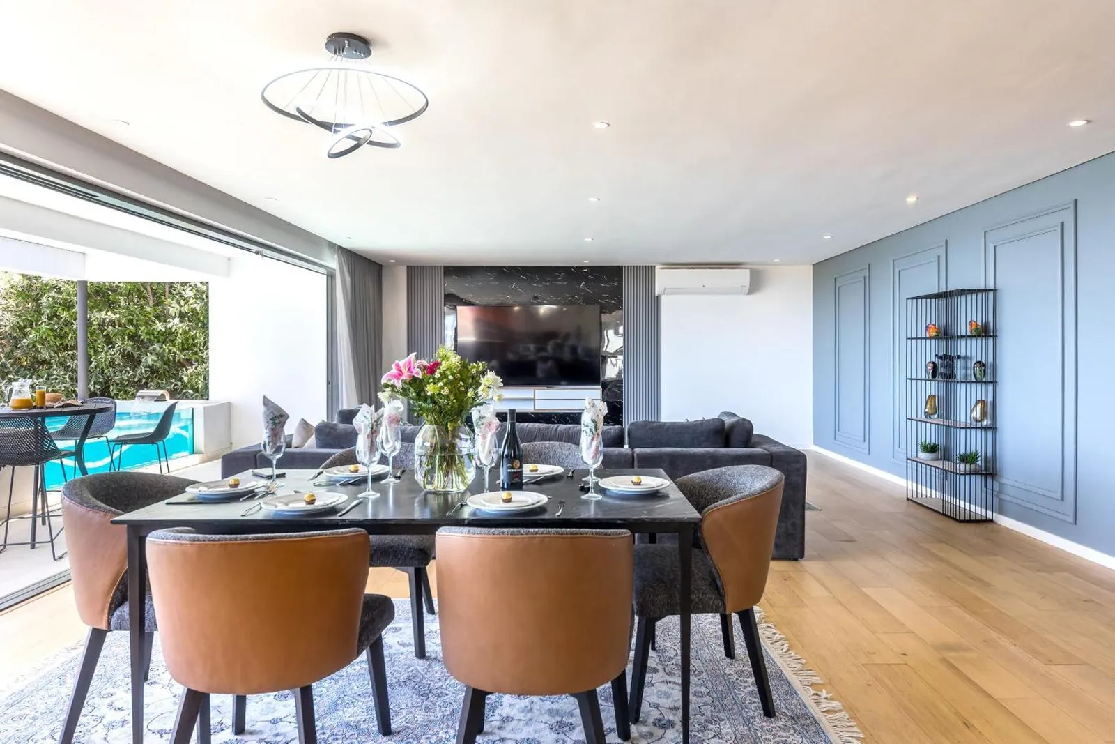 Dining table with the pool through open sliding doors
