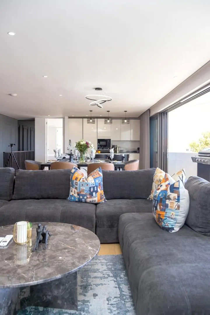Lounge with a deep corner sofa and open kitchen behind