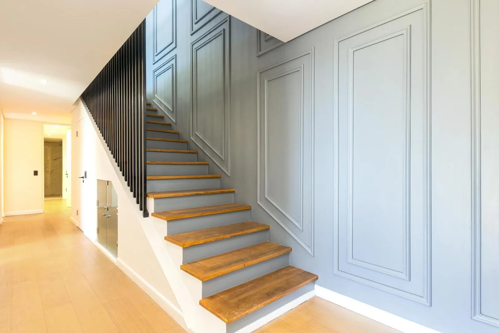 Timber staircase against a panelled wall