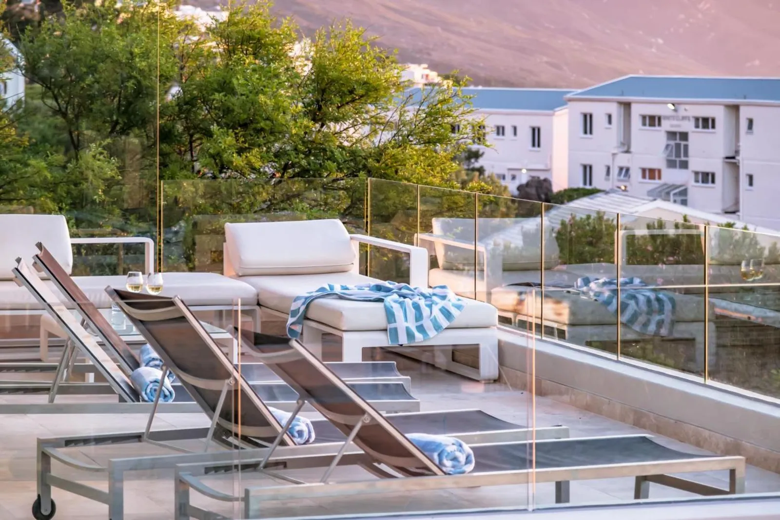 Pool deck with sun loungers and glass balustrade