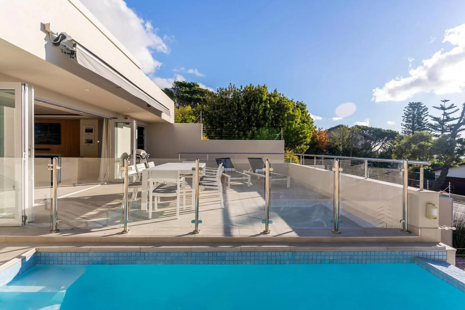 Pool with the living area's sliding doors open behind it