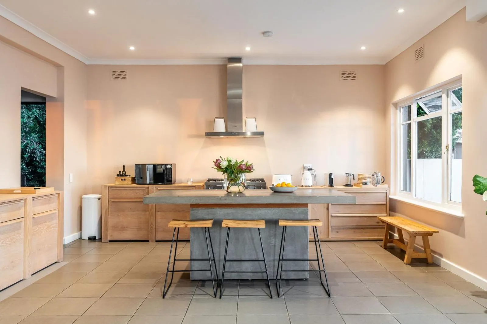 Kitchen island with a concrete counter and bar stools