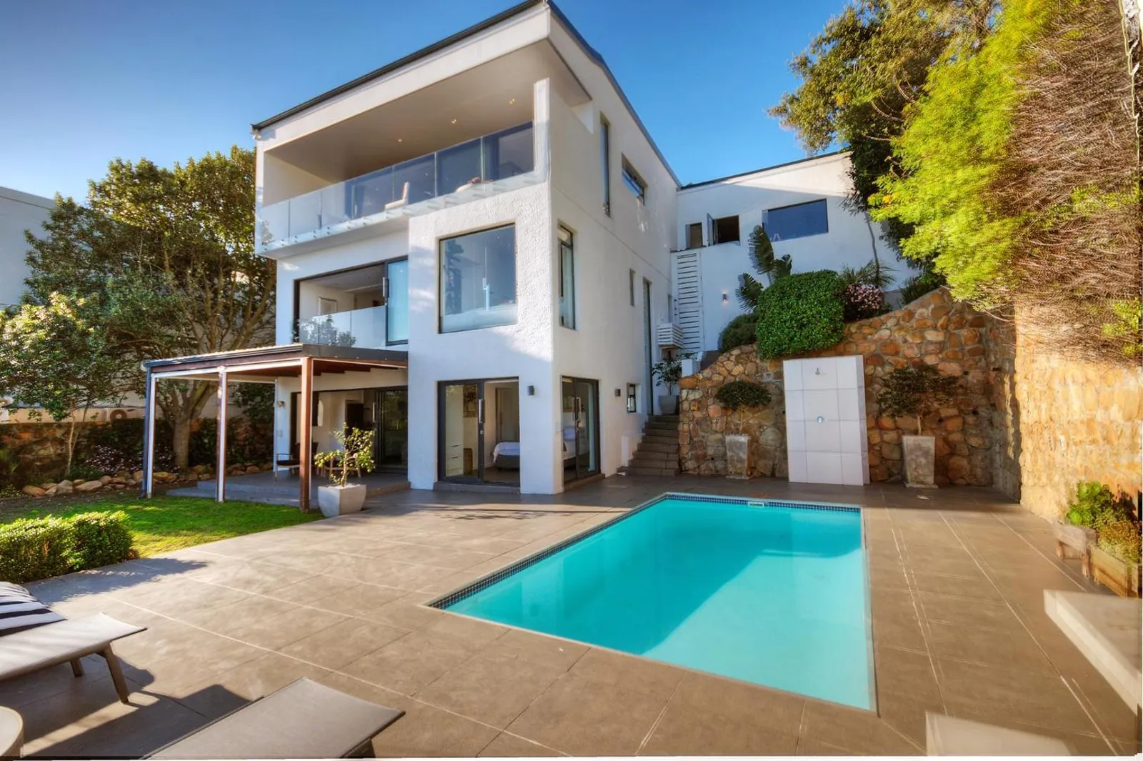 White modern villa exterior with a long pool deck