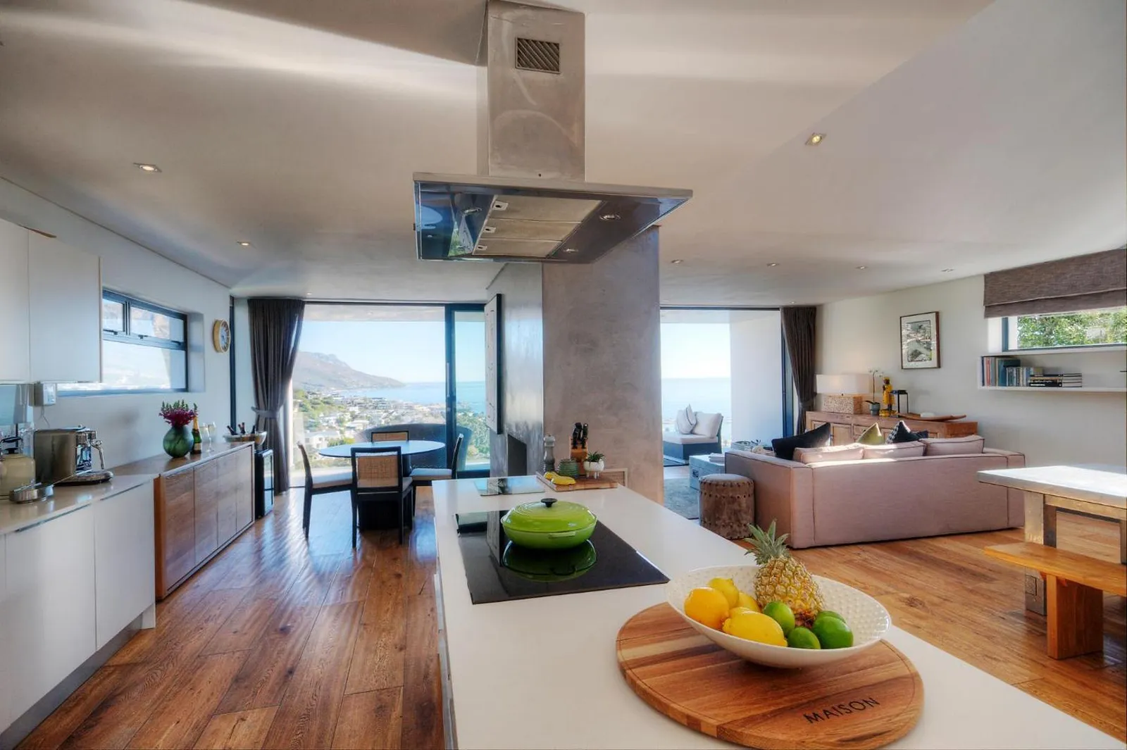 Open-plan living and dining with the sea through the glass